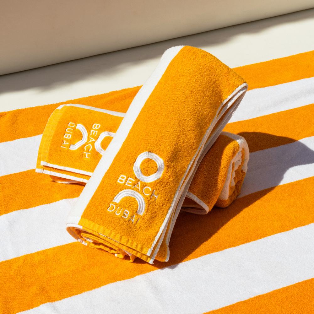 O Beach Towel placed on a poolside bed